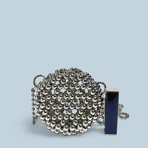 Mini silver beaded spherical bag compared with lipstick to show compact fashion size