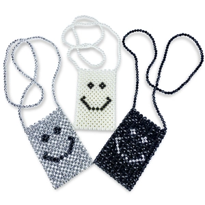 Detailed view of handmade beaded smiley face mini crossbody bags in white silver and black