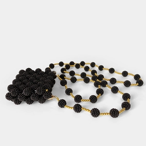 Detail of handmade black beaded mini bag with elegant gold and black shoulder strap