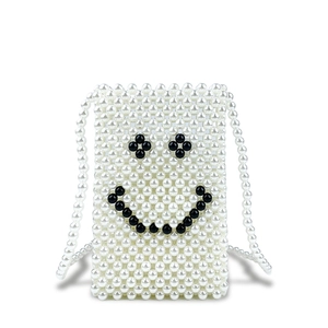 Detail of handmade pearl woven mobile phone bag with clover eye smiley face pattern