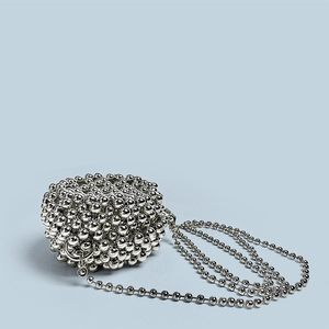 Detailed close-up of woven silver metal bead bag with reflective mirror finish texture