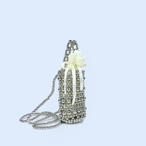 Detail of silver handmade beaded mini bag with satin bow and metal chain strap