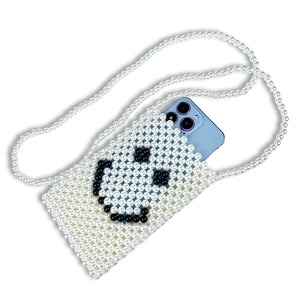Detail of handmade pearl beaded phone bag featuring a black smile face and long strap