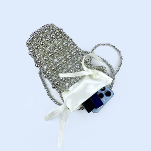 Close-up of handmade silver beaded mini bag with white satin drawstring pouch
