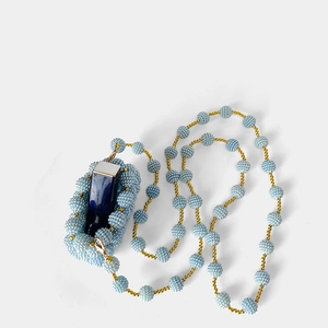 Close-up of light blue handmade beaded lipstick holder with a gold metal chain strap