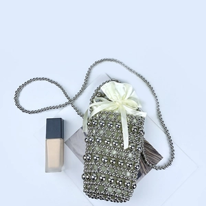 Detail of silver beaded mini bag with satin drawstring pouch and metallic chain strap