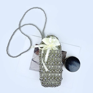 Close-up of handmade silver beaded mini crossbody bag with yellow silk drawstring lining