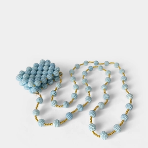 Detail of light blue handmade beaded mini bag with gold chain and round pearl accents