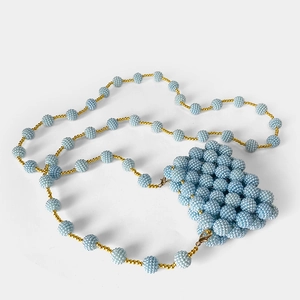 Detail of light blue handmade beaded mini bag with gold accents and detachable crossbody strap