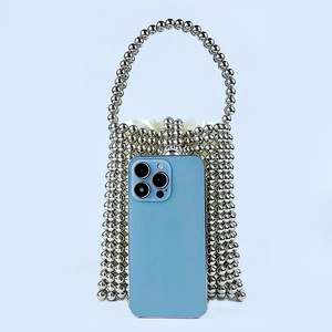 Close-up of silver beaded handbag with satin liner showing mini size with a smartphone