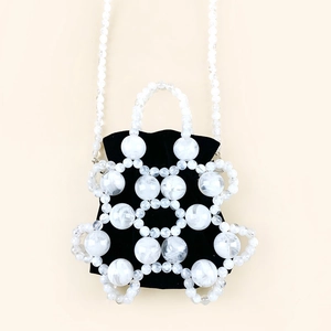Detailed view of white marble beads and black velvet drawstring pouch bucket bag