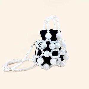 Detail of beaded bucket bag showing black velvet pouch and translucent white bead woven net