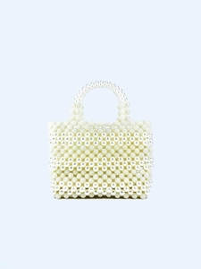 Detailed view of handmade white pearl woven handbag with textured berry bead patterns