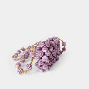 Macro view of purple handmade beaded bag with pearl finish and gold metal clasps