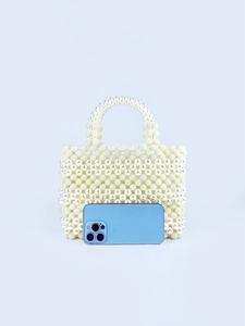 Handmade pearl bead handbag shown next to a smartphone for detailed size comparison