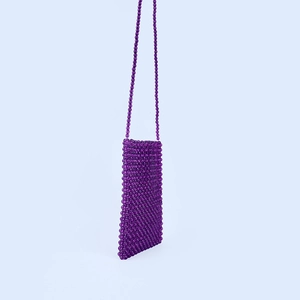 Détail du sac de téléphone en perles violettes montrant la texture tissée à la main
