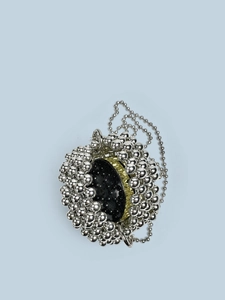 Minimalist silver beaded spherical crossbody bag with golden gear accent on light blue background
