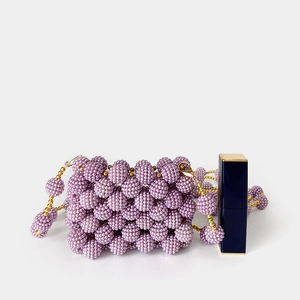 Close-up of a handmade mini purple beaded pearl evening bag with a golden metal chain