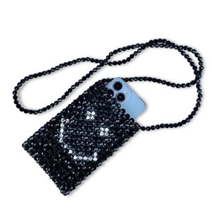 Detail view of handmade black beaded crossbody bag with smile face and phone storage