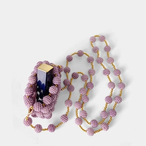 Detail of lavender handmade beaded mini bag with a gold chain and lipstick inside
