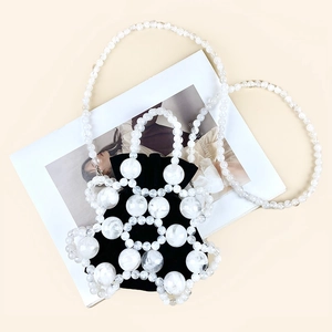Close-up of marble pattern beads and black drawstring pouch on a fashion magazine