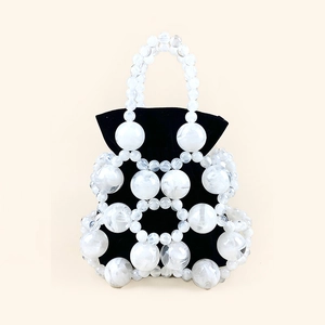 Detail of beaded bucket bag showing marble-textured beads and black drawstring pouch