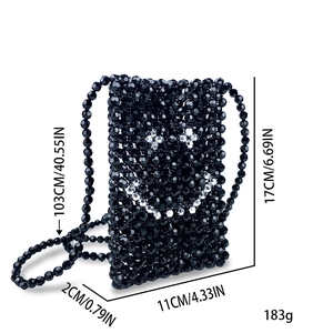 Detail view of handmade black beaded crossbody bag with white pearl smiley face design