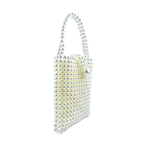 Detail of handmade beaded pearl handbag showing white lustrous pearls and woven texture