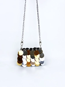 Macro shot of dual-tone gold and silver sequins on a handmade metallic chain bag