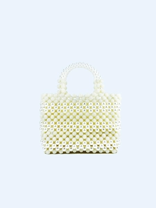 Macro detail of hand-woven pearl evening bag with intricate beaded wavy texture