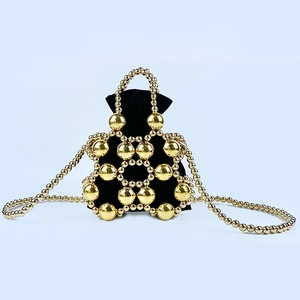 Detail of gold metal beaded bucket bag with black velvet drawstring pouch and strap