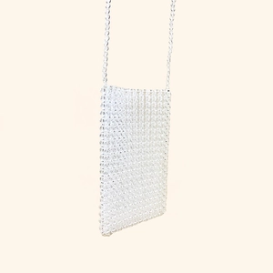 Vue détaillée du sac de téléphone en perles blanches fait main avec bandoulière tissée