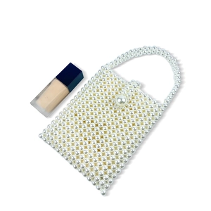 Detailed view of handmade beaded pearl handbag with square frame and large pearl clasp