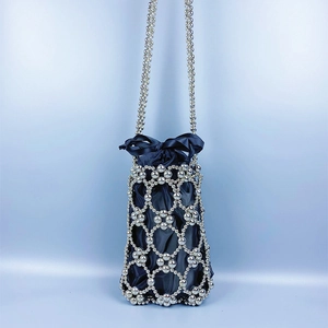 Detail of silver beaded bucket bag with blue satin drawstring and bow accent