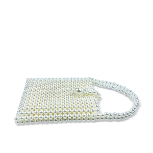 Detail of handmade beaded pearl handbag with vintage square shape and elegant clasp
