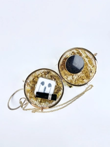 Macro view of gold spherical metal cage evening bag with luxury rhinestone handle