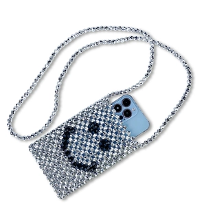 Detail of silver handmade beaded crossbody bag showing phone storage and smiley face pattern