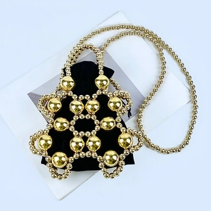 Detail of golden beaded bucket bag with black velvet drawstring pouch and shoulder strap