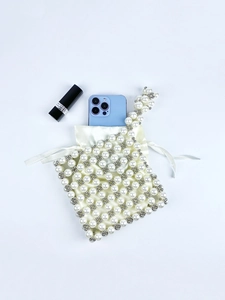 Detail of cream pearl beaded mini bag with satin lining and drawstring closure
