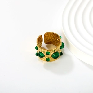Detail view of gold hammer textured wide open ring with green domed resin inlays