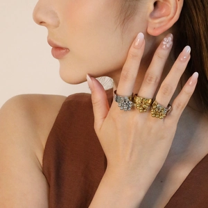 Detailed view of hammered 18K gold plated rings with bead clusters on a model's hand