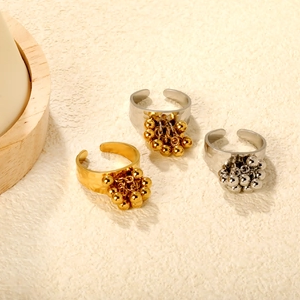 Detail of 18K gold and silver open rings featuring beaded tassel charm pendants