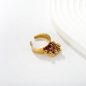 Detail of gold hammered texture open ring featuring a tassel of polished metal beads