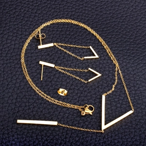 Detailed view of gold stainless steel V-shaped tassel necklace and long drop earrings set