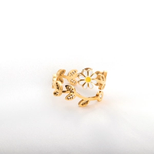 Détail d'une bague dorée ajustable avec fleur de marguerite et feuille de vigne sertie