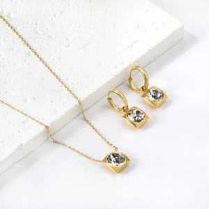 Vue détaillée du parure dorée avec pendentif carré et zircons ronds étincelants