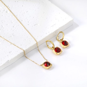 Détail d'une parure en or carrée avec pendentifs en rubis et boucles d'oreilles