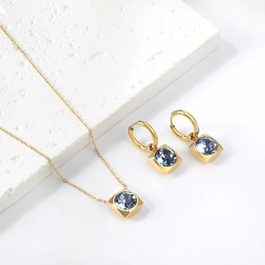 Détail de parure boucles d'oreilles et collier avec pierres carrées bleues sur pierre