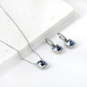 Détail d'un ensemble collier et boucles d'oreilles avec pierres carrées bleu clair