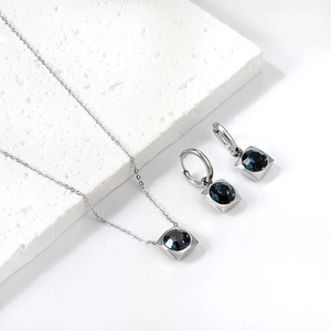 Détail du pendentif carré argenté et des boucles d'oreilles avec cristal bleu